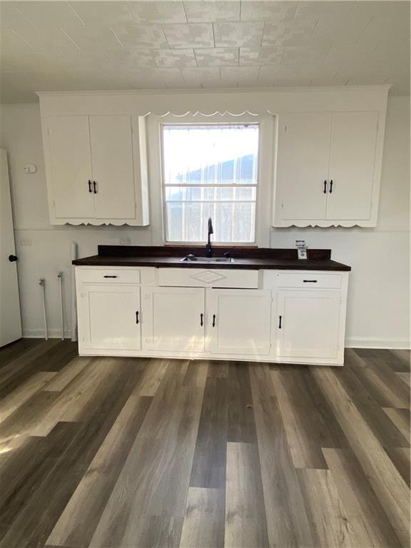 512 Fos Ave, Marrero, LA 70058 - kitchen with a sink, dark wood finished floors, and white cabinets