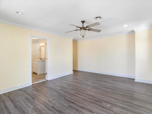 empty room featuring baseboards, visible vents, wood finished floors, ceiling fan, and crown molding