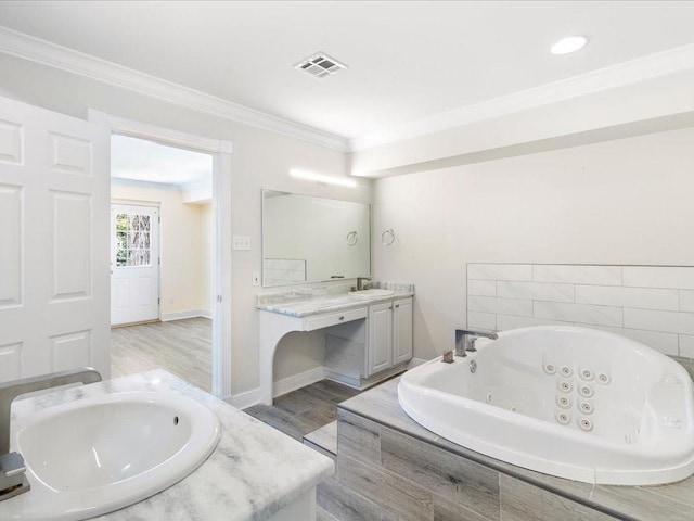 full bath with visible vents, wood finished floors, a whirlpool tub, vanity, and ornamental molding