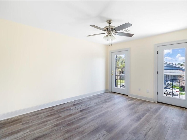 spare room featuring ceiling fan, baseboards, wood finished floors, and visible vents