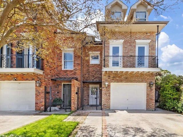 view of front of property featuring brick siding, driveway, a balcony, and a garage