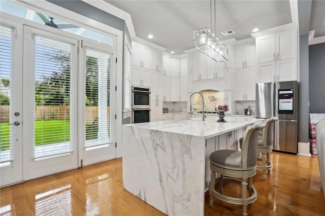 736 Belleville St, New Orleans, LA 70114 - kitchen with stainless steel fridge with ice dispenser, white cabinetry, backsplash, light stone counters, and recessed lighting