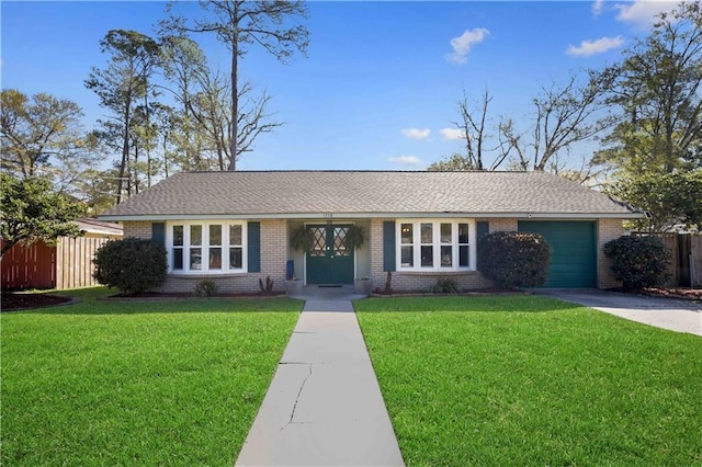 single story home featuring brick siding, driveway, a front lawn, and fence