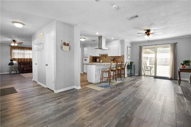 kitchen with visible vents, extractor fan, open floor plan, white cabinetry, and a ceiling fan
