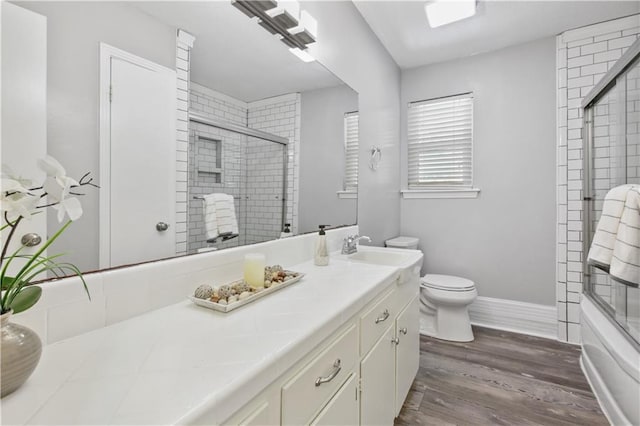 1558 Monaco Dr, Slidell, LA 70458 - full bath with vanity, toilet, wood finished floors, and combined bath / shower with glass door