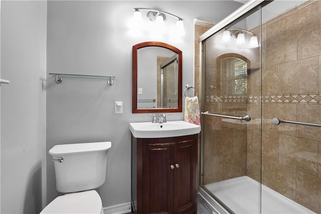 bathroom featuring a shower stall, vanity, and toilet