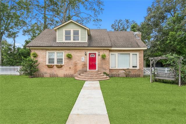 view of front facade featuring fence, a pergola, brick siding, and a front yard