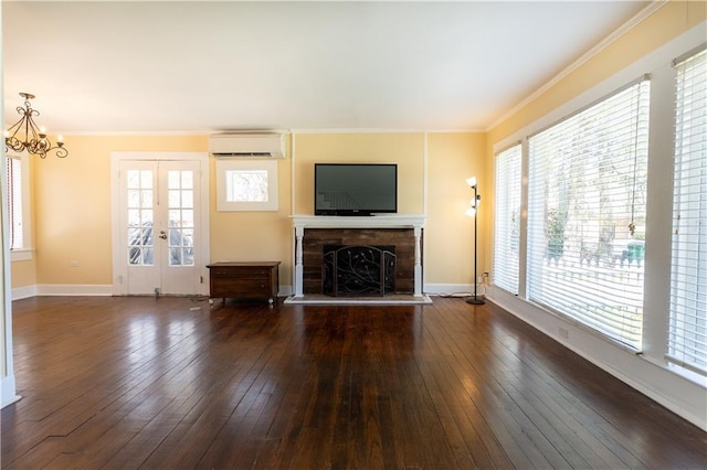 unfurnished living room with a fireplace with raised hearth, dark wood finished floors, baseboards, a wall mounted AC, and ornamental molding