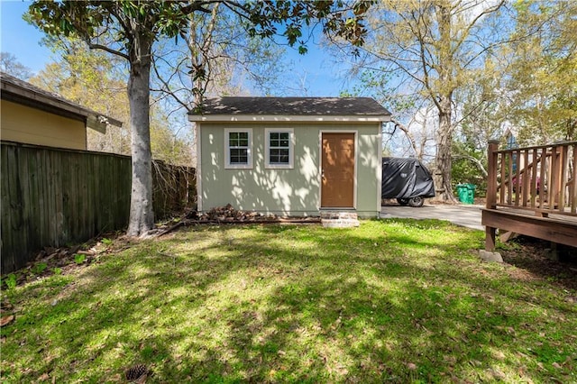 view of outdoor structure with fence and an outbuilding