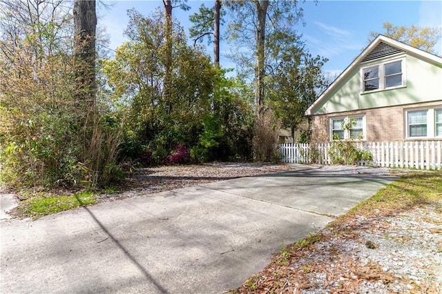 view of side of home with fence and brick siding