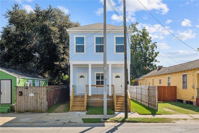 view of front of house featuring a porch and fence