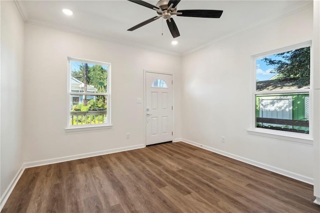 spare room featuring a healthy amount of sunlight, ornamental molding, and wood finished floors