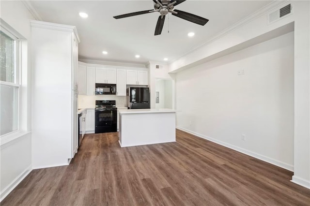 kitchen with visible vents, ornamental molding, dark wood-style flooring, light countertops, and black appliances