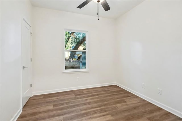 spare room with a ceiling fan, baseboards, and wood finished floors