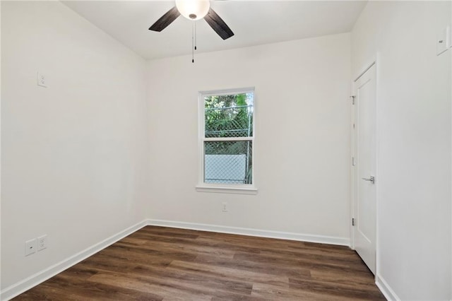 unfurnished room with baseboards, dark wood-style flooring, and ceiling fan