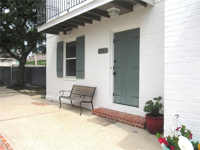 6720 Argonne Boulevard ., New Orleans, LA 70124 - property entrance with a patio, brick siding, fence, and a balcony