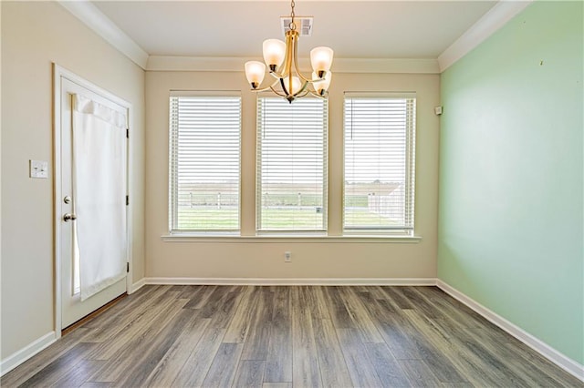 unfurnished dining area with visible vents, crown molding, baseboards, dark wood-type flooring, and a chandelier