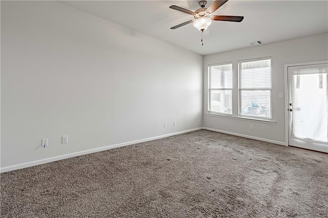 spare room featuring visible vents, baseboards, ceiling fan, and carpet floors
