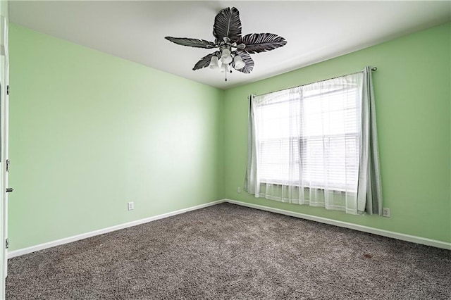 carpeted empty room featuring baseboards and ceiling fan