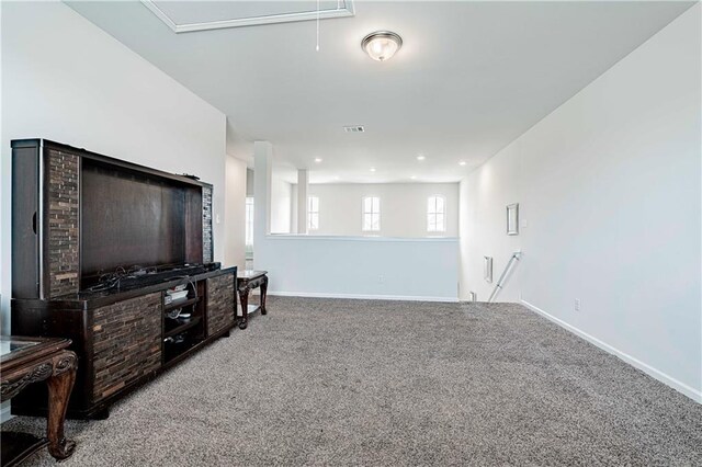 living area with attic access, carpet, baseboards, and visible vents