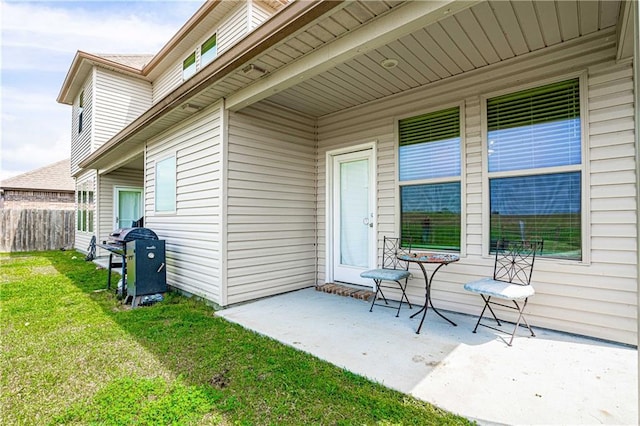 entrance to property featuring a yard, a patio area, and fence