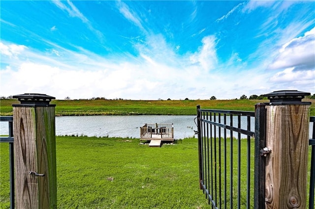 dock area with a yard and a water view