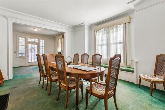 carpeted dining space featuring crown molding and visible vents