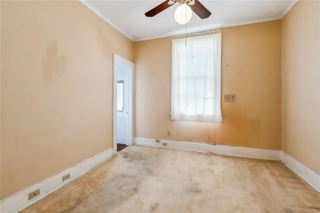 spare room with carpet floors, baseboards, a ceiling fan, and ornamental molding