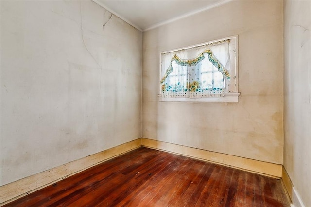 empty room with ornamental molding and wood-type flooring