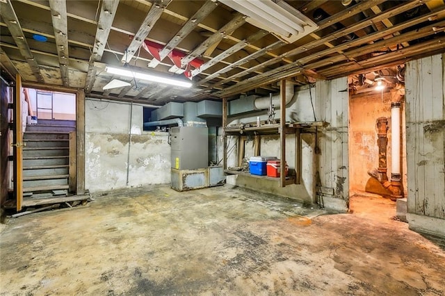 unfinished basement with heating unit and stairs