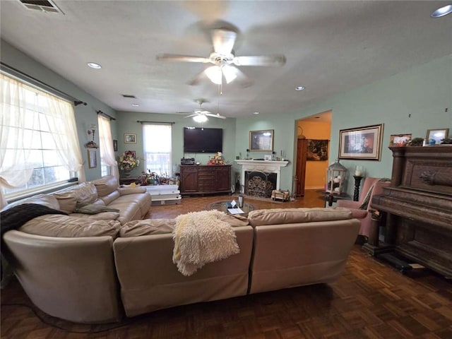 living area featuring a fireplace, recessed lighting, a ceiling fan, and visible vents