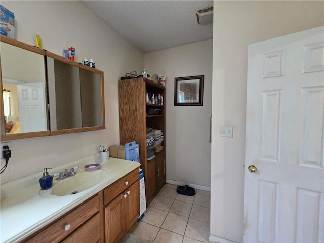 bathroom featuring visible vents, baseboards, vanity, and tile patterned flooring