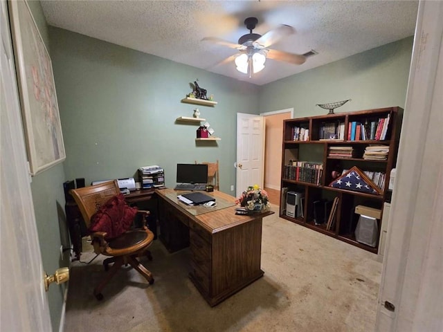 office space featuring visible vents, a textured ceiling, a ceiling fan, and carpet floors