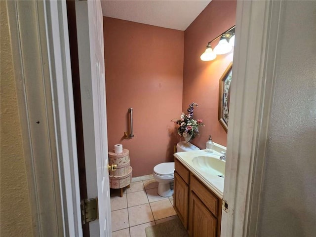 bathroom with tile patterned flooring, toilet, vanity, and baseboards