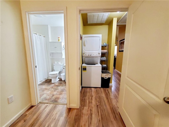 20996 Diversion Canal Rd, Saint Amant, LA 70774 - clothes washing area featuring stacked washer / dryer, wood finished floors, and baseboards