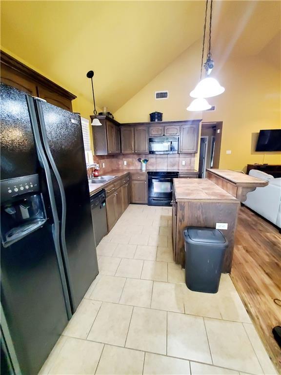 20996 Diversion Canal Rd, Saint Amant, LA 70774 - kitchen with visible vents, pendant lighting, a sink, tasteful backsplash, and appliances with stainless steel finishes
