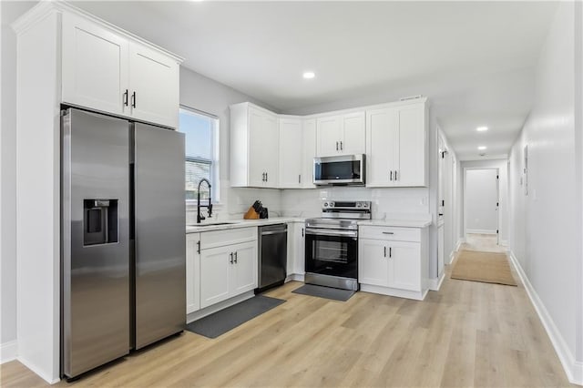 1413 Gordon St, New Orleans, LA 70117 - kitchen featuring stainless steel appliances, a sink, light countertops, white cabinets, and recessed lighting