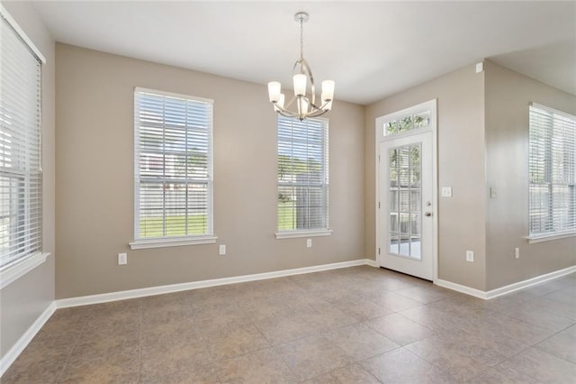 unfurnished dining area featuring tile patterned flooring, baseboards, and a notable chandelier