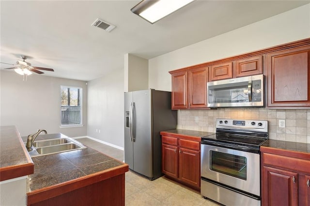 kitchen featuring tasteful backsplash, visible vents, stainless steel appliances, tile countertops, and a sink