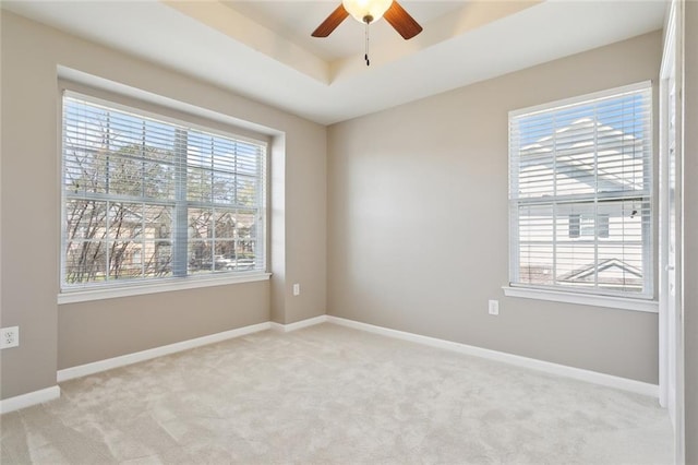 empty room featuring light carpet, a ceiling fan, and a healthy amount of sunlight