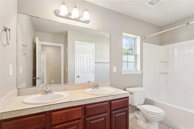 bathroom with double vanity, visible vents, a sink, and toilet