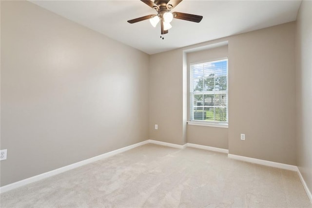 empty room with light colored carpet, baseboards, and ceiling fan