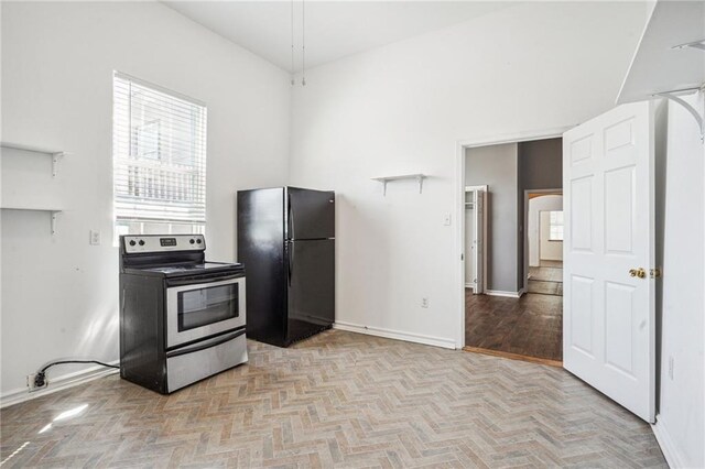 320709 Bienville St, New Orleans, LA 70119 - kitchen with baseboards, freestanding refrigerator, and stainless steel electric range