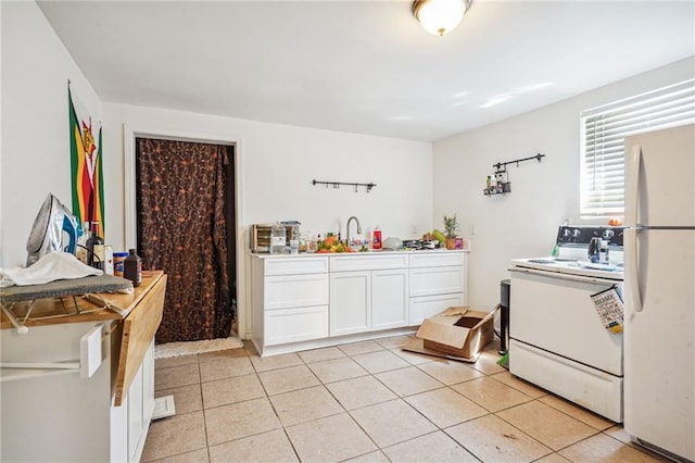 320709 Bienville St, New Orleans, LA 70119 - kitchen with white appliances, white cabinetry, a sink, and light tile patterned flooring