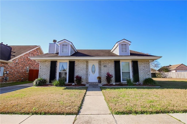 4504 Stella Dr, Meraux, LA 70075 - view of front of home featuring fence, roof with shingles, a front yard, brick siding, and a chimney