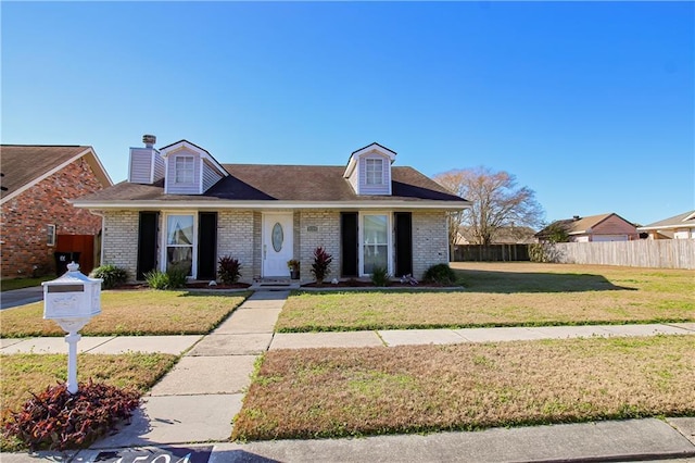 4504 Stella Dr, Meraux, LA 70075 - view of front of property featuring brick siding, a chimney, a front yard, and fence