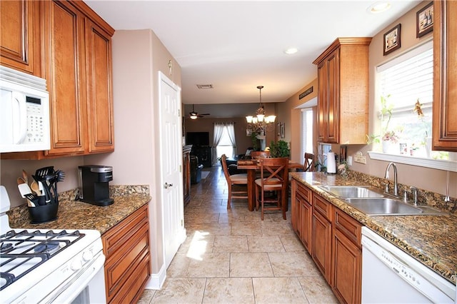 4504 Stella Dr, Meraux, LA 70075 - kitchen with white appliances, a sink, pendant lighting, brown cabinets, and a chandelier