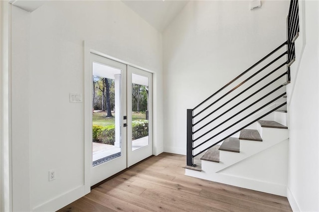 entrance foyer featuring french doors, baseboards, stairs, and wood finished floors