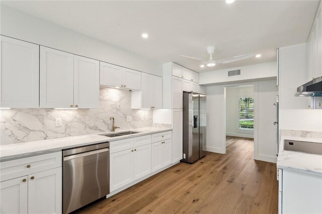 kitchen with stainless steel appliances, a sink, white cabinetry, backsplash, and recessed lighting