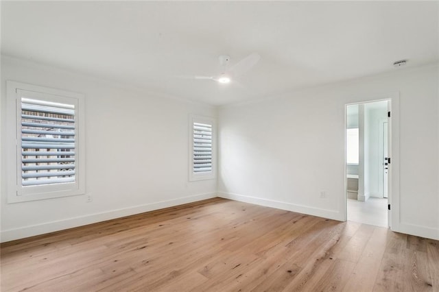 empty room with healthy amount of natural light, light wood-style flooring, ornamental molding, baseboards, and ceiling fan